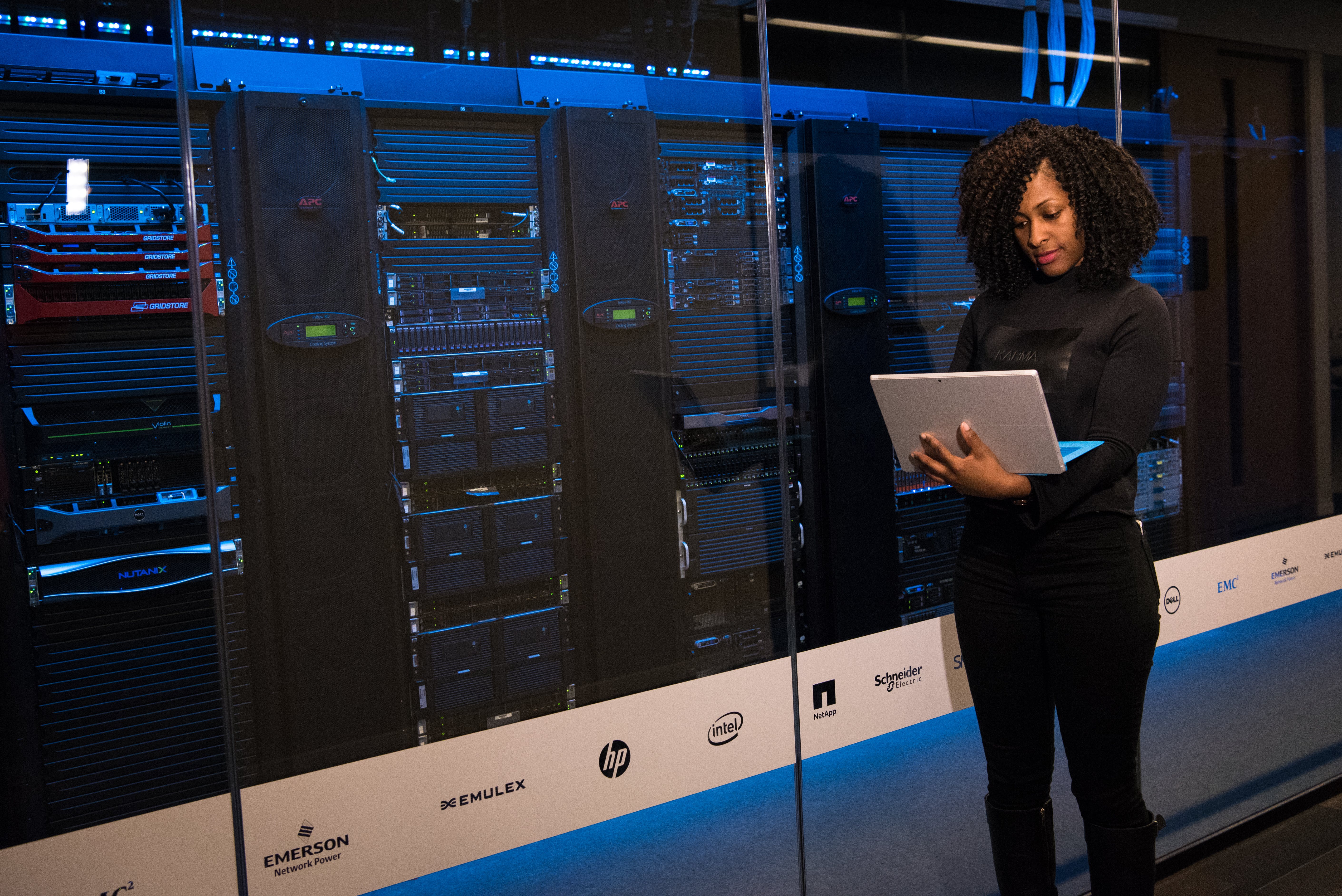 A lady in a server room holding a laptop